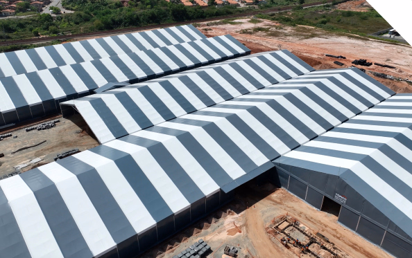 Imagem de um galpão completo com um caminhão na entrada